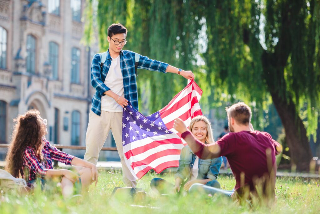 Multicultural Students With American Flag In Summer Park 1024x684